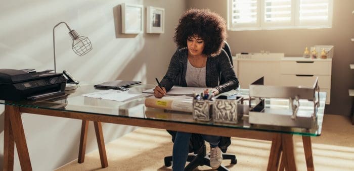 woman at desk taking notes